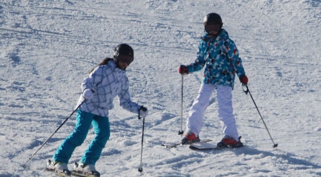 dos jovenes esquiando en una pista